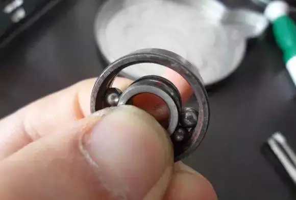 用手將軸承拿起，需要注意要向有滾珠的方向頂住